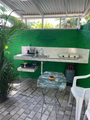 a green kitchen with a sink and a table at Centrally Located Room - 5 in Port Antonio