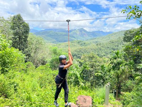 a person on a zip line in the jungle at Pepper and Clove Enclave in Puliyara