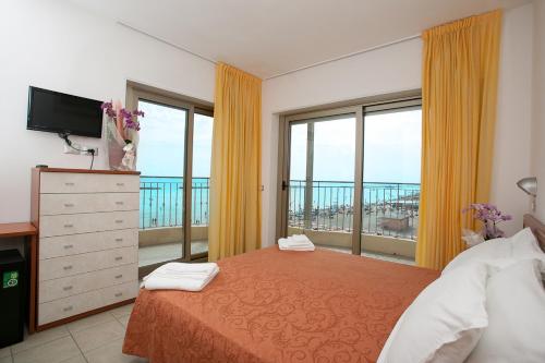 チェゼナーティコにあるHotel Adria Beach Clubのベッドルーム1室(ベッド1台、大きな窓付)
