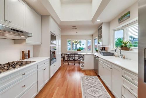 a kitchen with white cabinets and a stove top oven at Ocean & Bay Views Pool & Hot Tub Rooftop Patio in San Diego