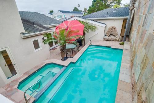 a swimming pool with an umbrella next to a house at Ocean & Bay Views Pool & Hot Tub Rooftop Patio in San Diego