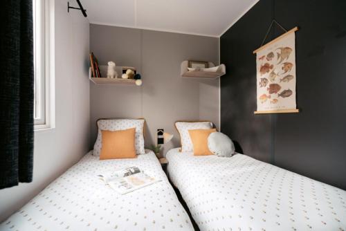 2 camas individuales en un dormitorio pequeño en Camping La Saline d'Arc et Senans, en Arc-et-Senans
