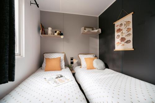 two twin beds in a small bedroom at Camping La Saline d'Arc et Senans in Arc-et-Senans