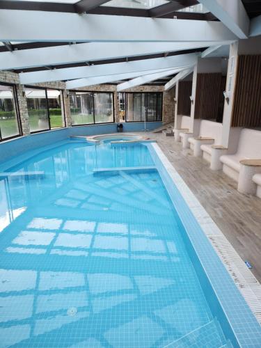 a large swimming pool with blue tiles in a building at St Spas in Velingrad