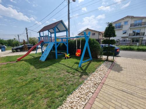 a playground with a slide in the grass at Vila duMio in Eforie Nord