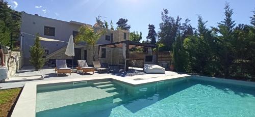 a swimming pool in front of a house at Renaissance Modern Stone House at Vryses - Private pool in Vryses