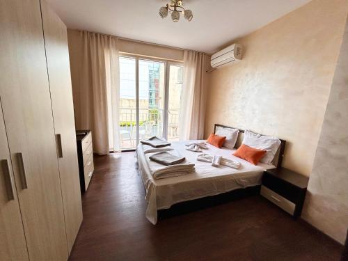 ein Hotelzimmer mit einem Bett und einem großen Fenster in der Unterkunft North Beach Apartments in Primorsko