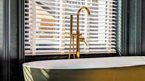 a bathroom with a bath tub and a window at INNit Bliss in Brighton & Hove