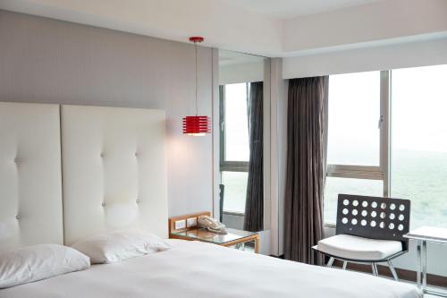 a hotel room with a bed and a chair at 觀海樓海景大飯店 Hotel Cloud Riverside in Tamsui
