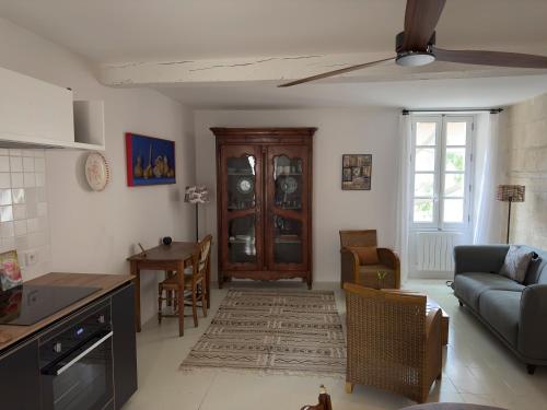 eine Küche und ein Wohnzimmer mit Sofa und Tisch in der Unterkunft Cœur d'Arles in Arles