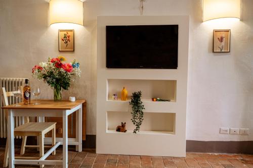 a living room with a flat screen tv on a wall at Antica Casa Dei Rassicurati in Montecarlo