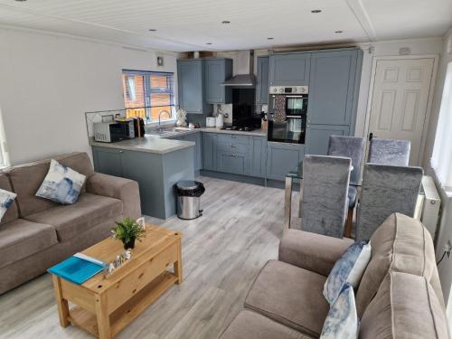 a living room with two couches and a kitchen at Windermere lodge,sleeps 6 in Windermere