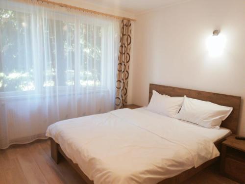una camera con un letto bianco e una finestra di Gold Apartments a Baia Mare