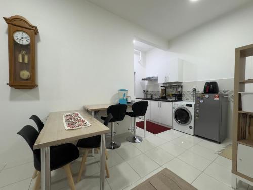 a kitchen with a table and chairs and a clock at A Room - Stay With the Host in Ipoh
