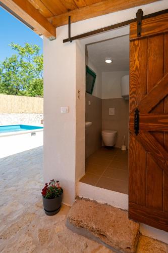 a bathroom with a toilet and a sliding door at Didovi dvori in Seline