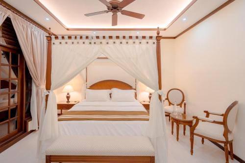 una camera con letto e ventilatore a soffitto di Alafehi Retreat a Fuvahmulah