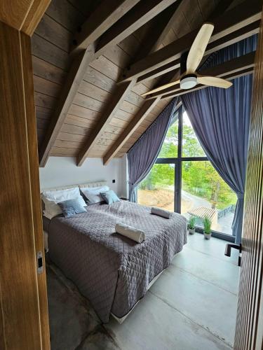 a bedroom with a bed with a ceiling fan at Dom w Czerwonej Dolinie Haus im Roten Tal Seidorf Sosnówka` in Sosnówka
