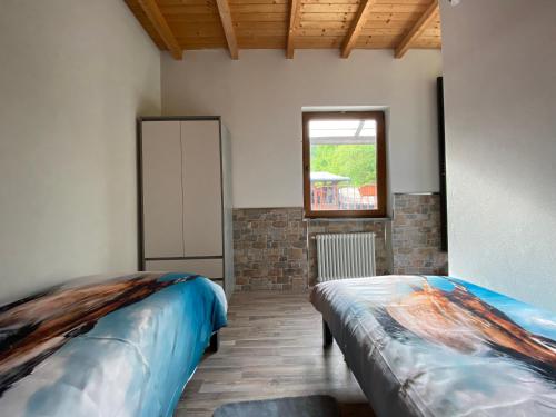 Pokój z 2 łóżkami i oknem w obiekcie Horse room w mieście Bagnasco