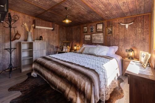 una camera con un letto in una stanza con pareti in legno di O'Tel Park a Le Bernard