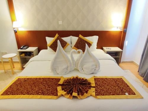 a hotel room with a white bed with a flower on it at Aquavista Hotel & Suites in Aqaba