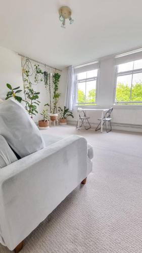 Sala de estar blanca con cama blanca y ventanas en Fresh and Sparkling - Free Parking, en Crystal Palace