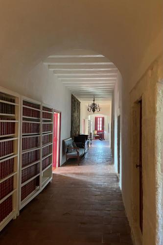 an empty hallway with a room with racks of books at Domaine du Couvent de Saint Julien in Bonifacio