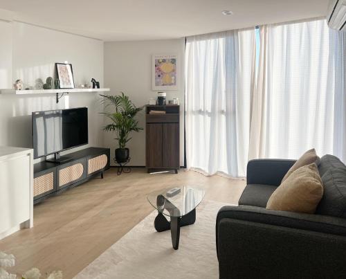 a living room with a couch and a tv at Sky View 1B1B APT in the CBD in Melbourne