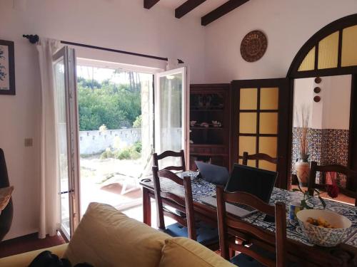 a living room with a table and chairs and a glass door at Casa Do Bosque in Nadadouro