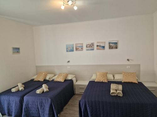 two beds in a room with shoes on them at B&B EDEN OGLIASTRA in Tortolì