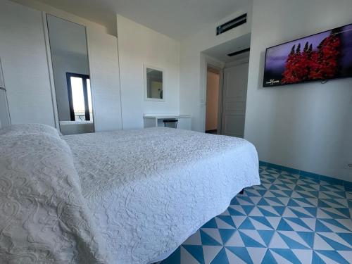 ein Schlafzimmer mit einem weißen Bett und einem TV an der Wand in der Unterkunft Hotel Boutique Ischia in Ischia