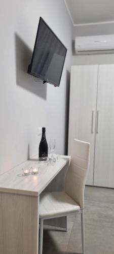 einen Tisch mit einem TV und zwei Weingläsern darauf in der Unterkunft Room's Stromboli in San Ferdinando