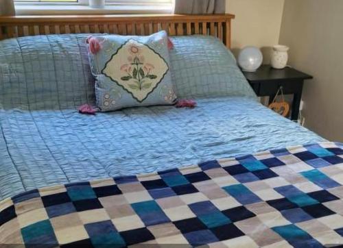 1 cama con edredón azul y almohada en Lissadell Lodge en Wexford