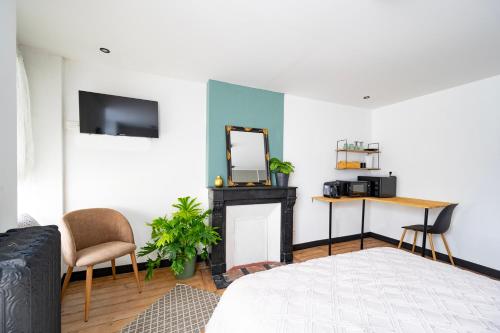 een slaapkamer met een bed, een spiegel en een tafel bij Élégante chambre avec salle de douche privative in Montivilliers