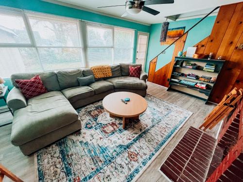 ein Wohnzimmer mit einem Sofa und einem Tisch in der Unterkunft Sweet Sunny Summit House in Greensboro