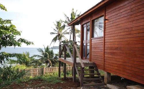 a wooden house with a ladder next to a window at Sonho Non in Santana