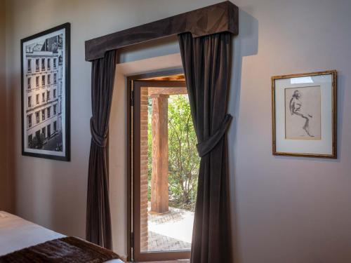 a mirror in a bedroom with a door and a window at Paradis Agricole in Pietrasanta