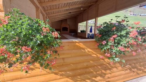 two potted plants on a wooden porch with flowers at Cabana Lazea in Arieşeni