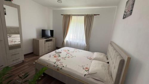 a small bedroom with a bed and a window at Cabana Lazea in Arieşeni