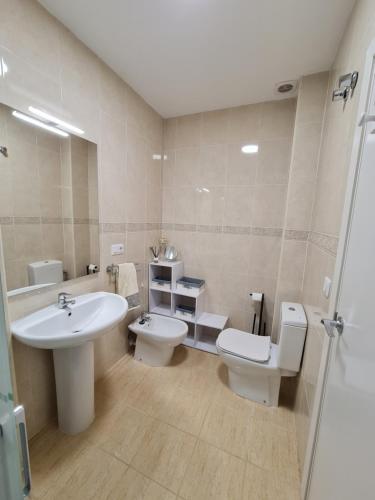 een badkamer met een wastafel, een toilet en een wastafel bij Bonrepòs Las Brisas apartamento planta baja en la playa in Alcossebre