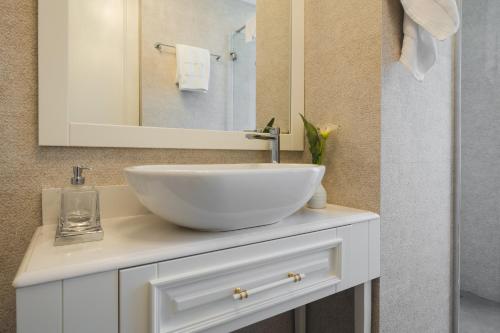 a bathroom with a white sink and a mirror at Vissi d'Arte Serviced Apartments in Budva