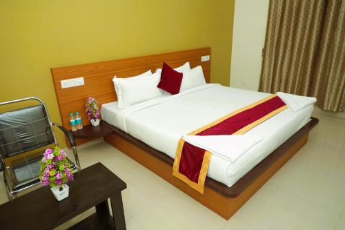 ein Hotelzimmer mit einem großen Bett und einem Tisch in der Unterkunft Hotel Shri Durga International in Bangalore
