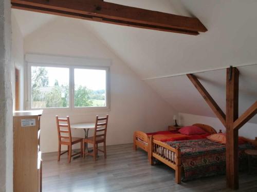 Schlafzimmer mit einem Bett, einem Tisch und Stühlen in der Unterkunft gite La Forêt in Ungersheim