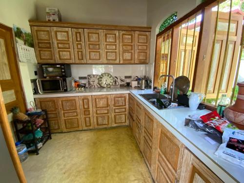 a kitchen with wooden cabinets and a sink at Angelica Villa in Bentota