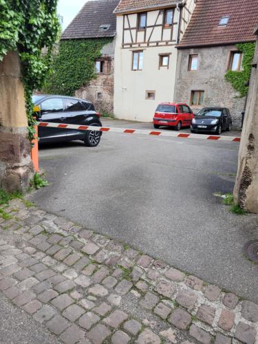Deux voitures garées sur le côté d'une rue dans l'établissement Appartement Atypique, à Soultz-Haut-Rhin