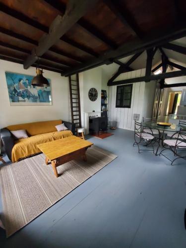 ein Wohnzimmer mit einem Bett und einem Couchtisch in der Unterkunft Maison du Lac avec jacuzzi privatif en option in Rouffignac Saint-Cernin