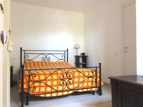 ein Schlafzimmer mit einem Bett mit einer orangefarbenen Bettdecke in der Unterkunft Casa Berso' in Marina di Cecina