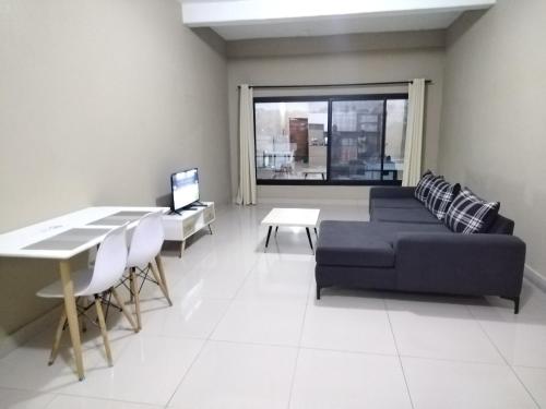 Milestone City - Appartements à louer في أنتاناناريفو: غرفة معيشة مع أريكة وطاولة