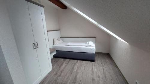 a small room with a bed and a staircase at Gasthuus Ulenhoff in Westoverledingen