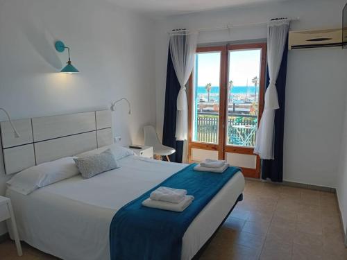 a bedroom with a bed with a view of the ocean at Hostal Santa Gemma in Sant Vicenç de Montalt