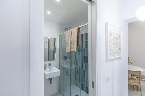 ein Bad mit einer Glasdusche und einem Waschbecken in der Unterkunft Al Cortiletto in Avola
